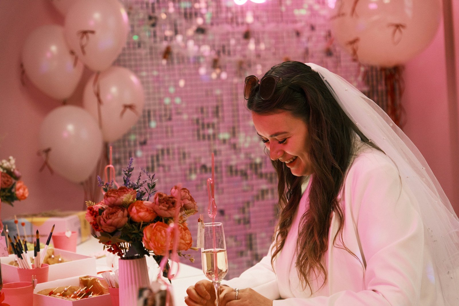 A bride laughing at a bright pink hen party